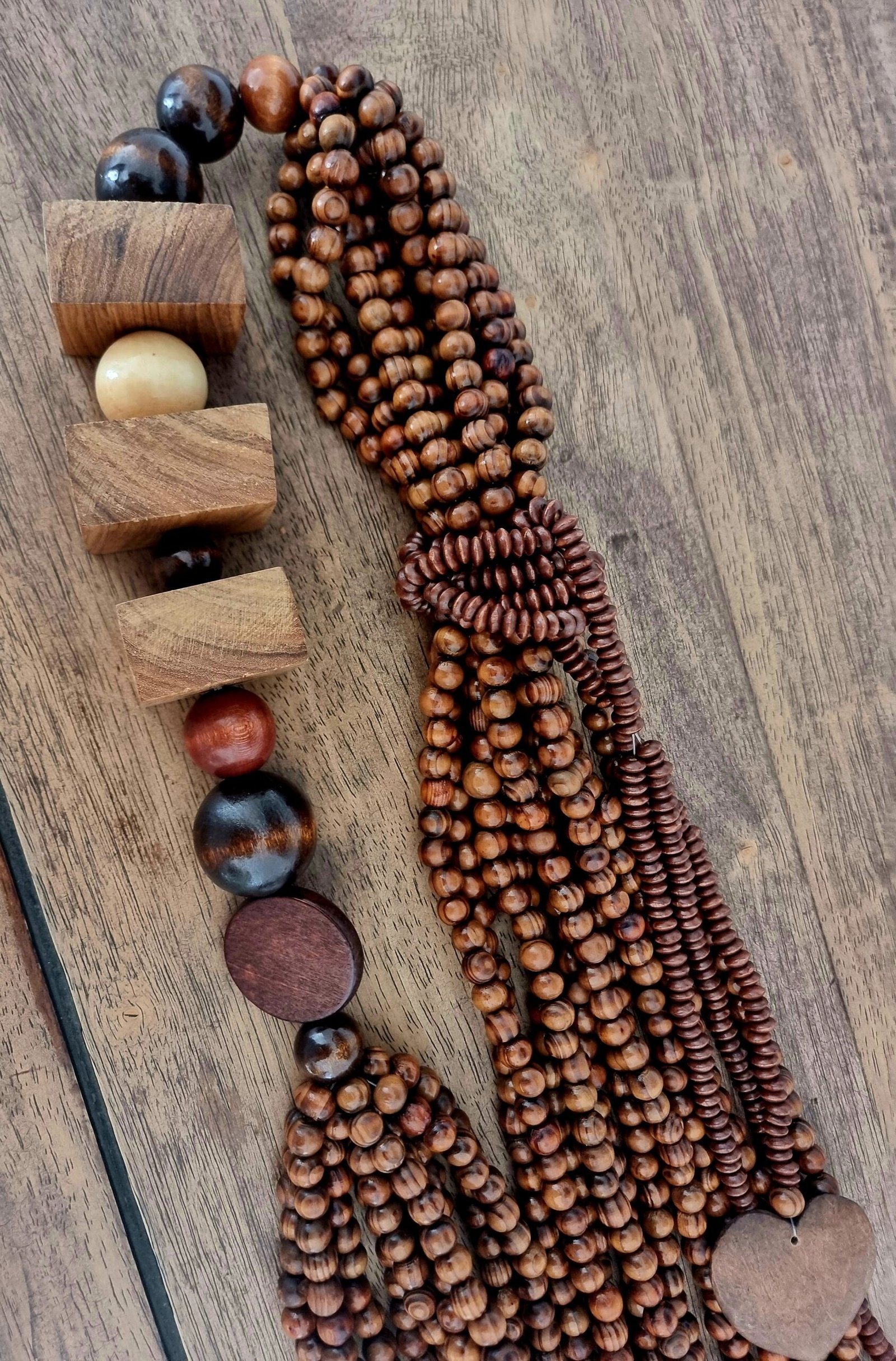 suspension décorative artisanale en perles de bois naturelles et formes sculptées, création Ayãm.